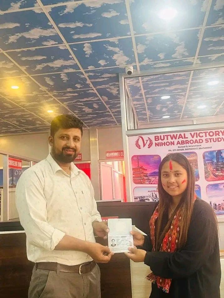A counsellor handing a passport to a smiling student at the office