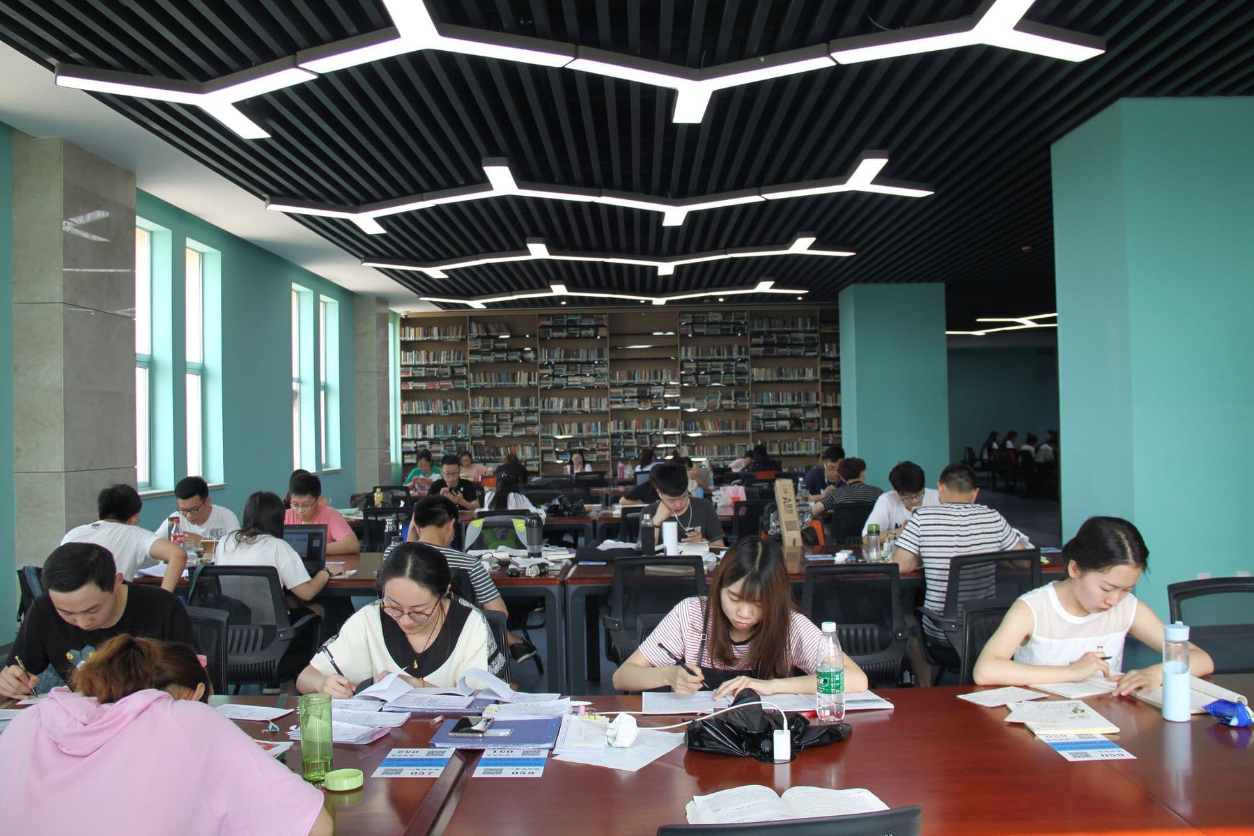 Students studying together at long tables in a university library